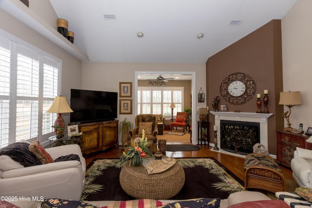 living room featuring visible vents, wood finished floors, ceiling fan, and vaulted ceiling