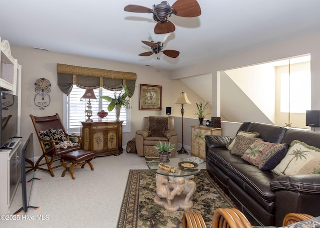 living room featuring visible vents, light colored carpet, and ceiling fan