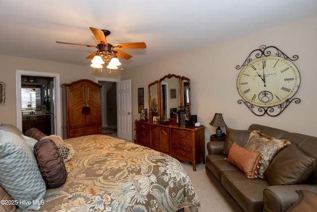 bedroom featuring connected bathroom, light carpet, and a ceiling fan