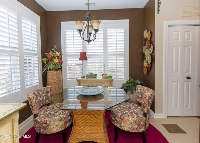 tiled dining space with visible vents, baseboards, and a notable chandelier