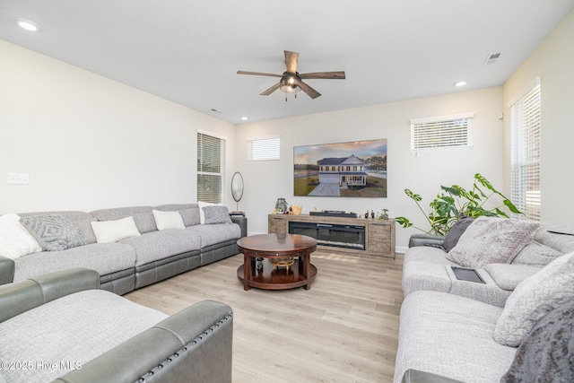 living room featuring light hardwood / wood-style floors and ceiling fan