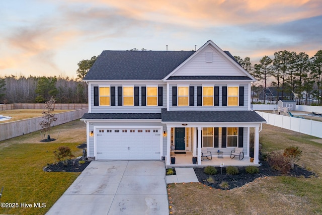 view of front of property with a garage, a yard, and covered porch