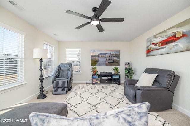 living area featuring light carpet and ceiling fan