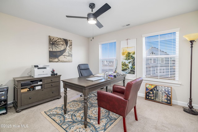 carpeted home office featuring ceiling fan