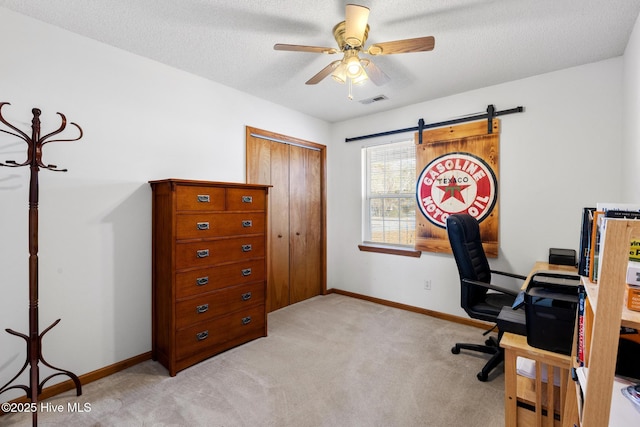 office area featuring ceiling fan, a textured ceiling, and light carpet