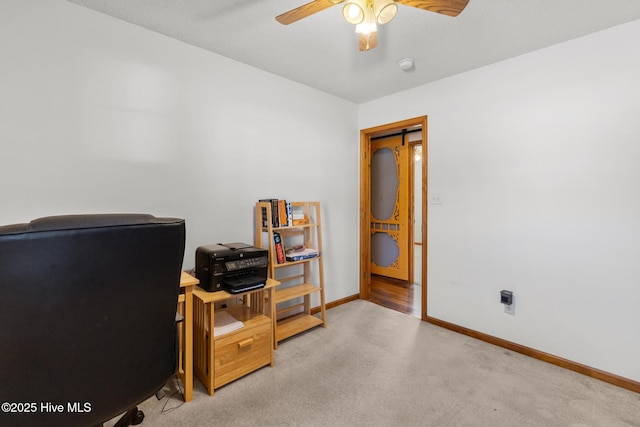 carpeted home office featuring ceiling fan