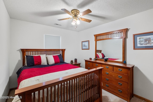 carpeted bedroom featuring ceiling fan and a textured ceiling