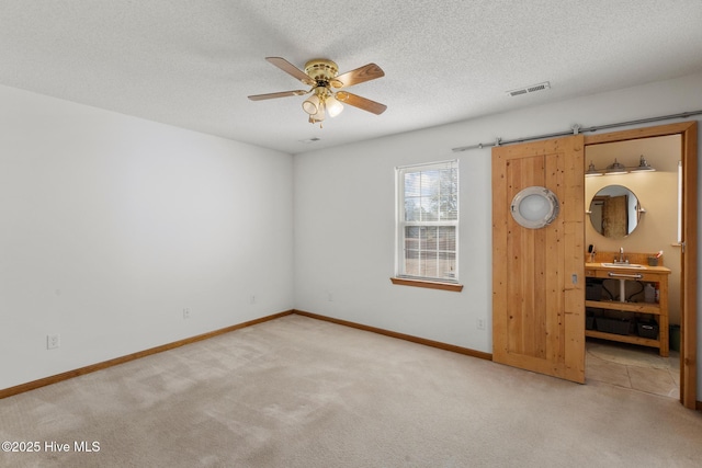 empty room featuring carpet floors, sink, and a textured ceiling