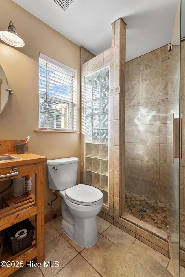 bathroom with toilet, an enclosed shower, and tile patterned flooring