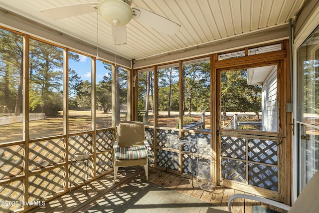 unfurnished sunroom featuring ceiling fan