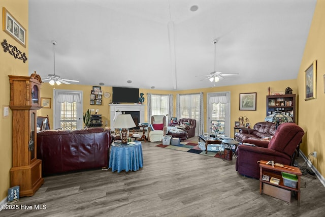 living room featuring ceiling fan, hardwood / wood-style flooring, and lofted ceiling