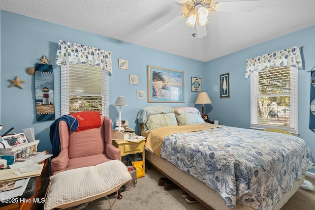 bedroom with ceiling fan, a textured ceiling, and light carpet