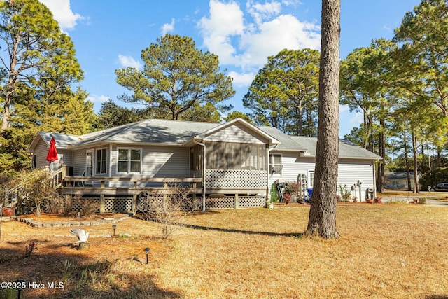 ranch-style house with a sunroom, a front lawn, and a deck