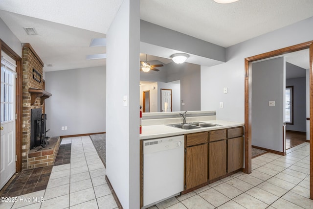 kitchen featuring sink, light tile patterned floors, a textured ceiling, and dishwasher