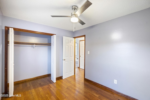 unfurnished bedroom with hardwood / wood-style flooring, ceiling fan, and a closet