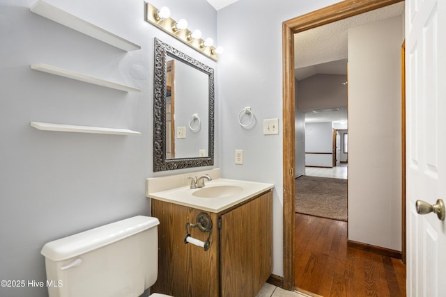 bathroom featuring vanity, hardwood / wood-style flooring, a textured ceiling, and toilet