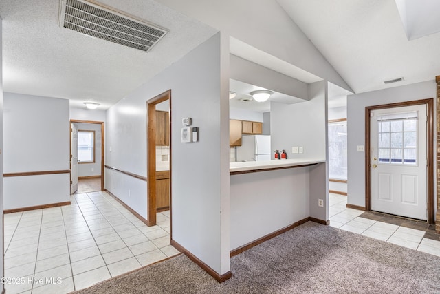 foyer with light tile patterned flooring and vaulted ceiling