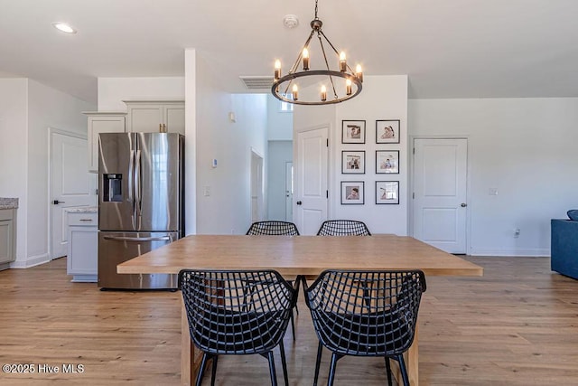 dining area with a chandelier and light hardwood / wood-style floors