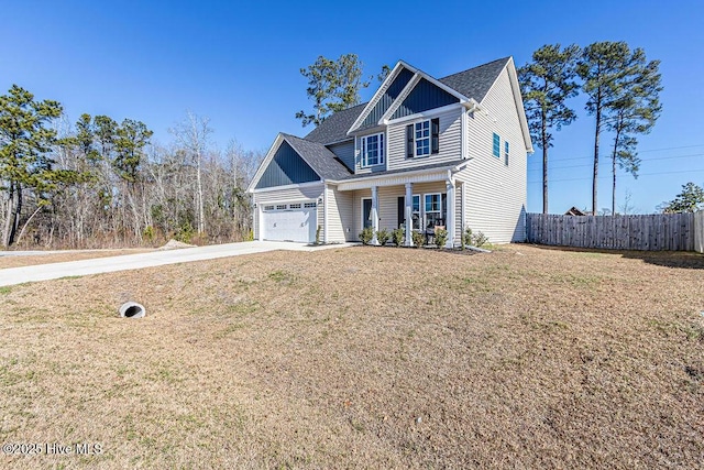 view of front facade featuring a garage, a front lawn, and covered porch