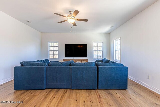 living room with light hardwood / wood-style flooring, ceiling fan, and plenty of natural light