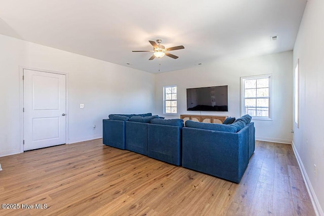 living room with ceiling fan, plenty of natural light, and light hardwood / wood-style floors