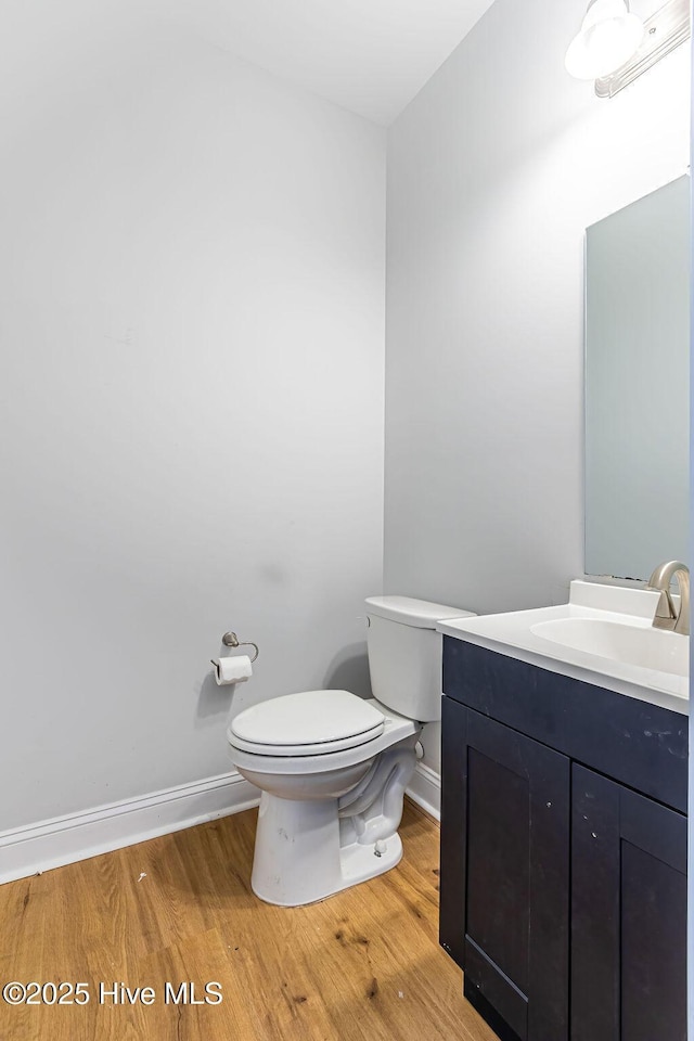 bathroom with hardwood / wood-style flooring, vanity, and toilet