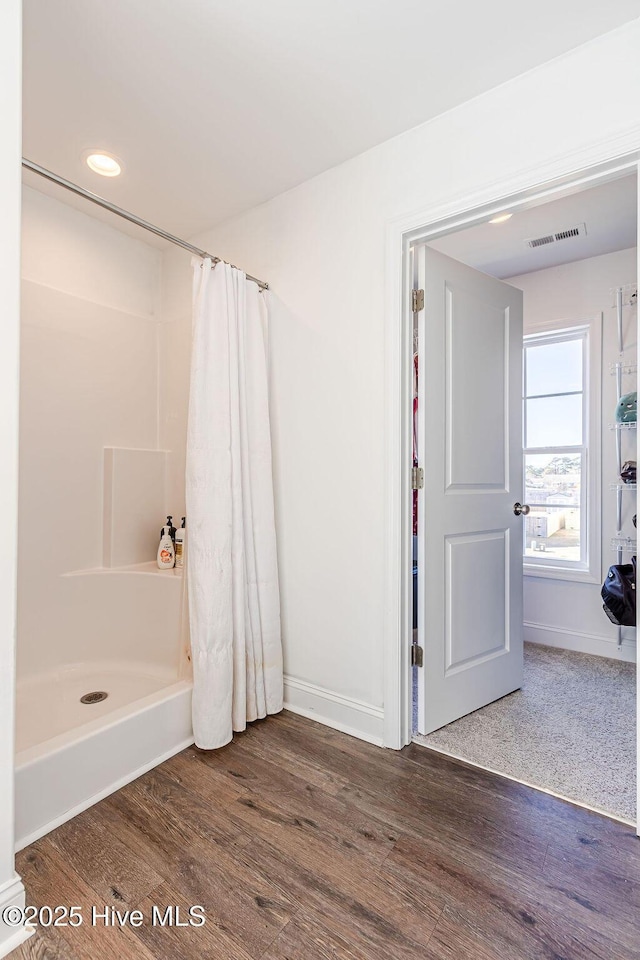 bathroom featuring wood-type flooring and walk in shower