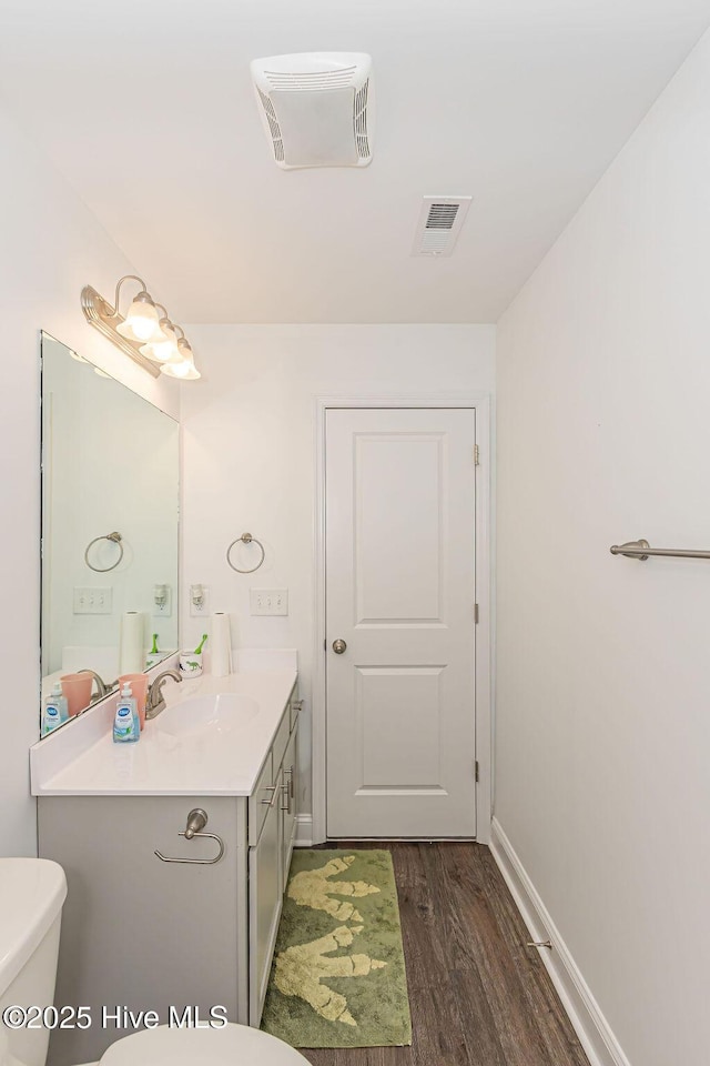 bathroom with hardwood / wood-style flooring, vanity, and toilet