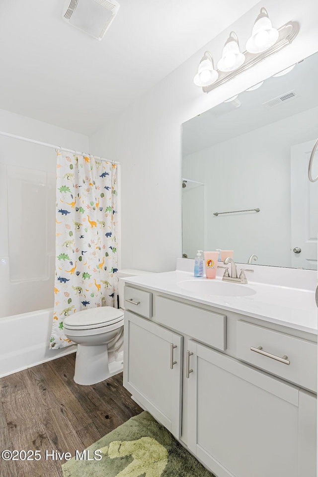 full bathroom with hardwood / wood-style flooring, vanity, toilet, and shower / bath combo with shower curtain