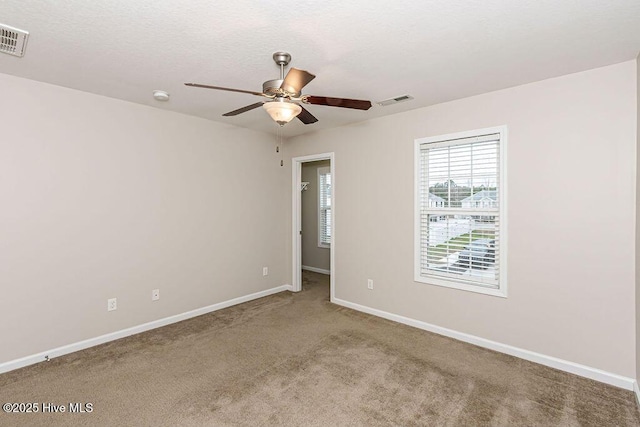 carpeted spare room featuring ceiling fan