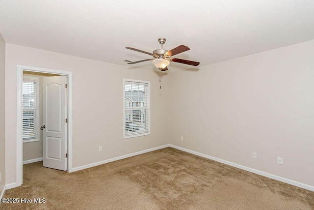 carpeted empty room with ceiling fan and a healthy amount of sunlight