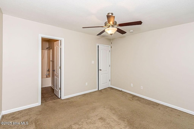 unfurnished bedroom with connected bathroom, carpet floors, and ceiling fan