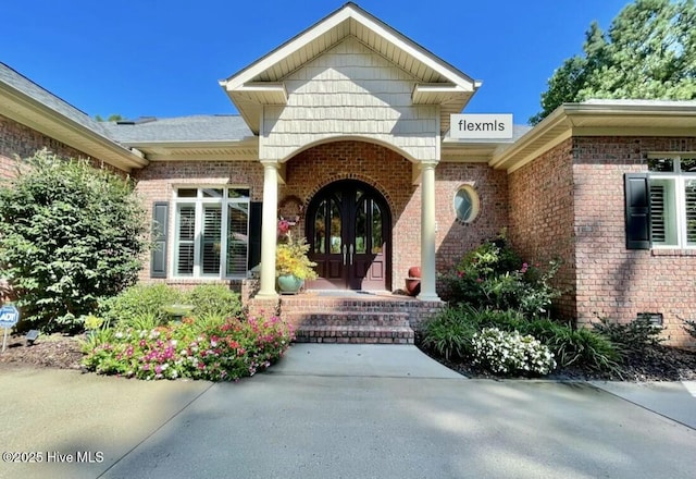 view of exterior entry featuring covered porch