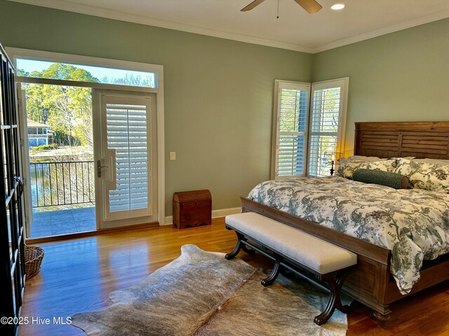 bedroom with ceiling fan, access to exterior, light hardwood / wood-style floors, multiple windows, and ornamental molding