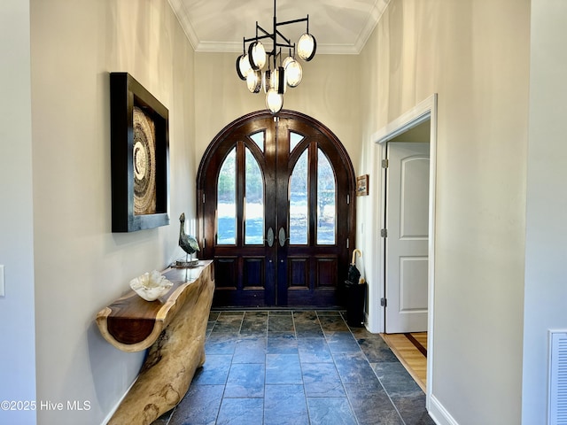 foyer with french doors, a notable chandelier, and ornamental molding