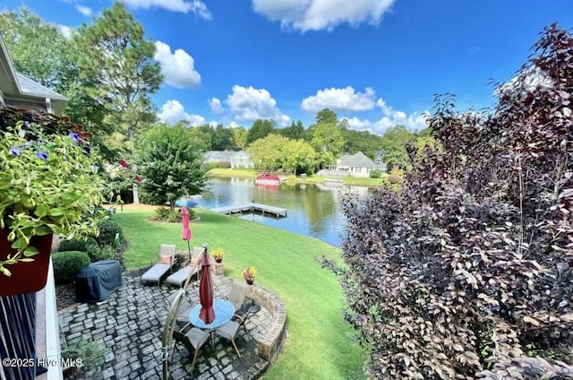 view of yard with a patio area, a dock, and a water view