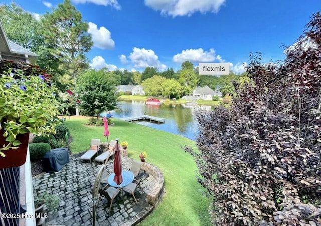 view of yard with a water view, a dock, and a patio