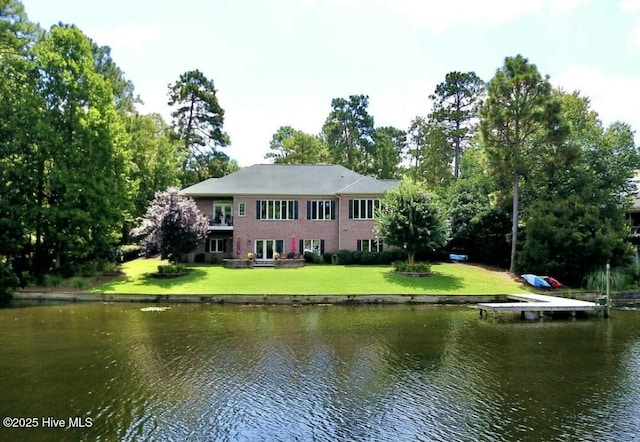 back of property featuring a lawn and a water view