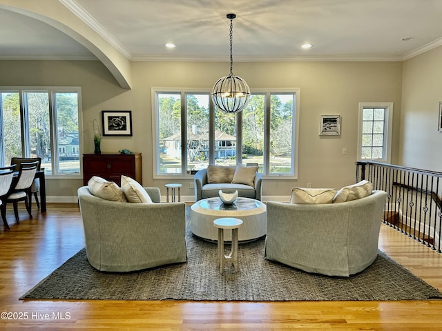 living room with an inviting chandelier, crown molding, and hardwood / wood-style floors