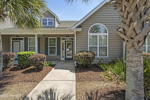 7195 Bonaventure St SW Apt 104, Ocean Isle Beach, NC 28469 - view of exterior entry featuring covered porch and a shingled roof