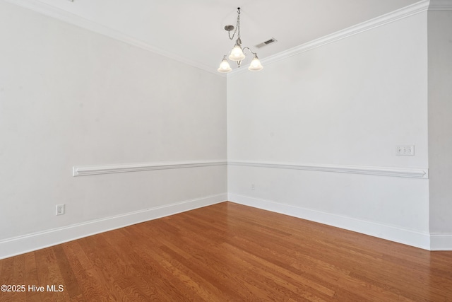 7195 Bonaventure St SW Apt 104, Ocean Isle Beach, NC 28469 - spare room featuring wood finished floors, baseboards, ornamental molding, and a chandelier