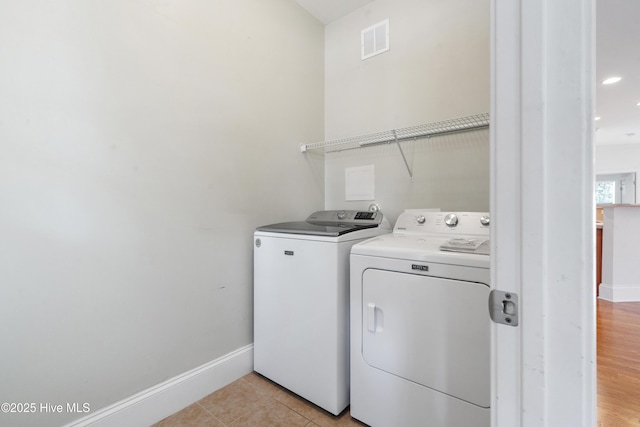 7195 Bonaventure St SW Apt 104, Ocean Isle Beach, NC 28469 - washroom featuring washer and clothes dryer, baseboards, and light tile patterned flooring