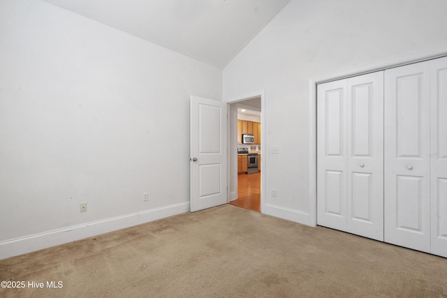 7195 Bonaventure St SW Apt 104, Ocean Isle Beach, NC 28469 - unfurnished bedroom with carpet flooring, high vaulted ceiling, baseboards, and a closet
