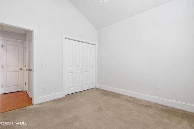 7195 Bonaventure St SW Apt 104, Ocean Isle Beach, NC 28469 - unfurnished bedroom featuring carpet, attic access, high vaulted ceiling, baseboards, and a closet