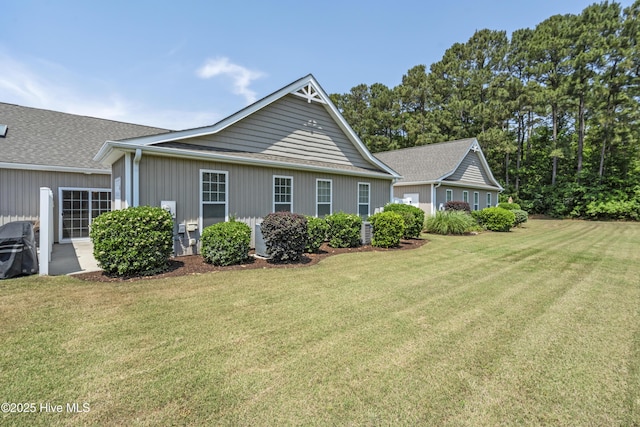 7195 Bonaventure St SW Apt 104, Ocean Isle Beach, NC 28469 - view of home's exterior featuring a lawn and roof with shingles