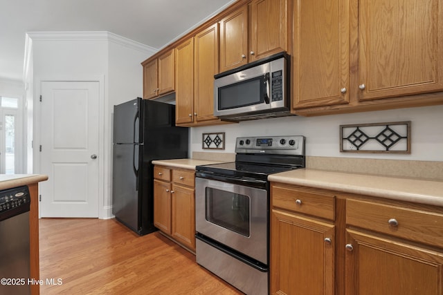7195 Bonaventure St SW Apt 104, Ocean Isle Beach, NC 28469 - kitchen featuring appliances with stainless steel finishes, brown cabinets, ornamental molding, and light countertops