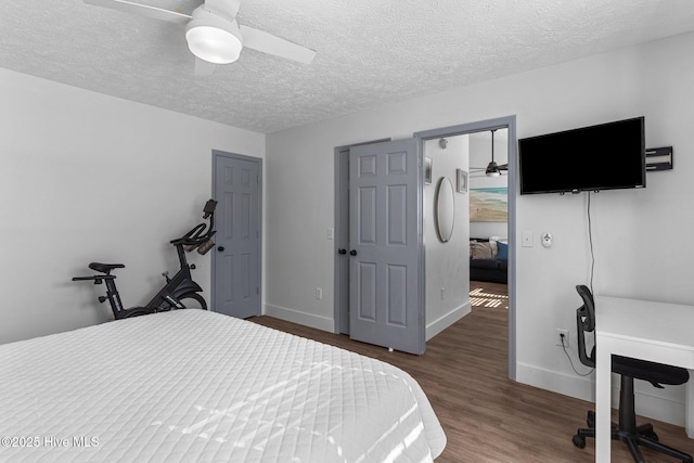 bedroom with ceiling fan, dark hardwood / wood-style flooring, and a textured ceiling