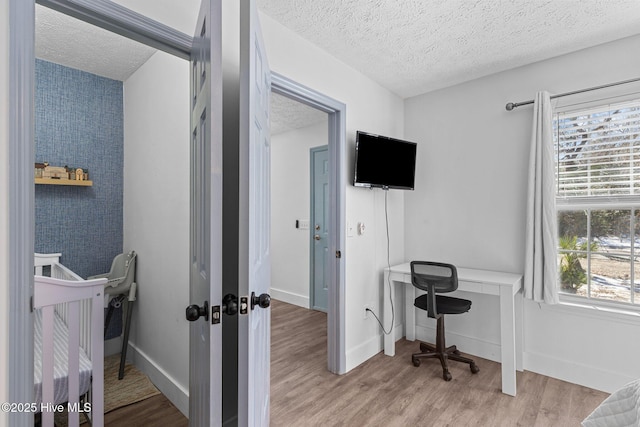 home office featuring a textured ceiling and light hardwood / wood-style floors