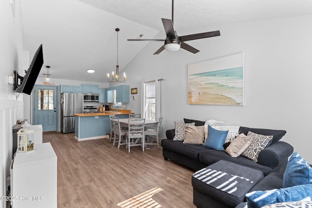 living room featuring high vaulted ceiling, ceiling fan, and light hardwood / wood-style flooring