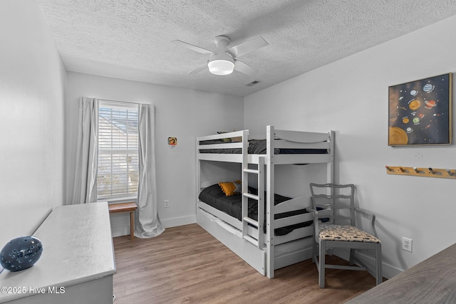 bedroom featuring hardwood / wood-style flooring, ceiling fan, and a textured ceiling